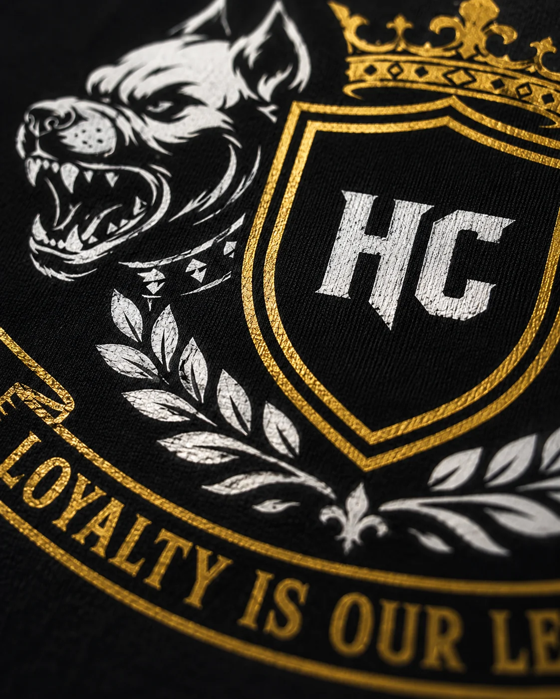 Macro close up of the gold Hardcore Crew crest printed on black fabric
